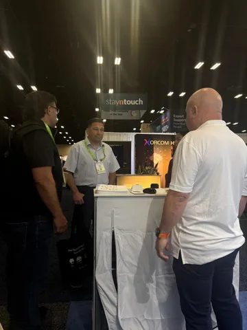 GratifID representative speaking with conference attendees at the TIPMO booth during HITEC