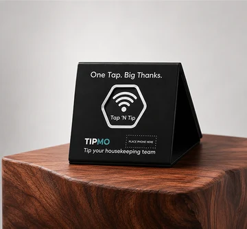 TIPMO Desk Tag — a black tent-style tabletop NFC sign reading One Tap. Big Thanks., resting on a polished wood block
