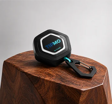 TIPMO Keychain Tag — a hexagonal black NFC tag on a teal loop with a carabiner, resting on a polished wood block