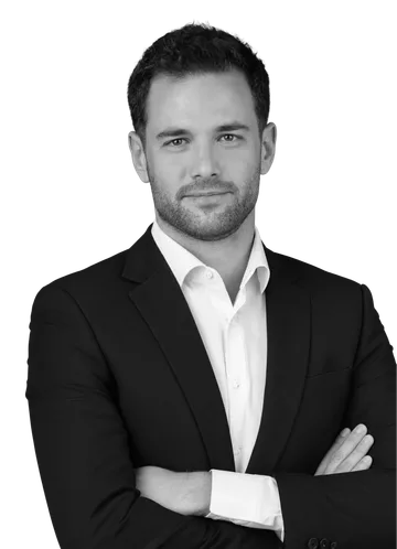 Black-and-white portrait of a man in a black blazer and white shirt